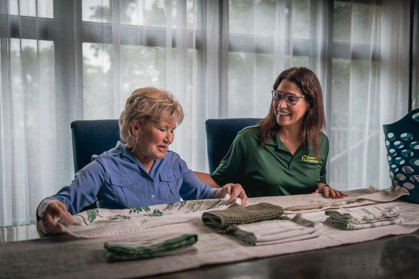 Home Instead Care Giver and their client doing chores together