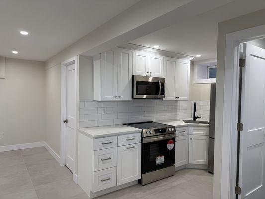 White shaker kitchen cabinet with quarts countertop and subway backsplash tiles