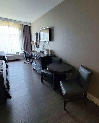 View of dresser, table, desk, and TV