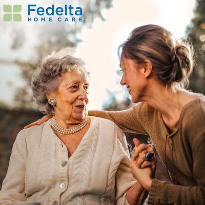 A client and caregiver smile at each other