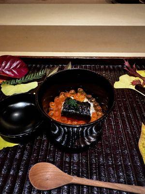 A very wet risotto covered with ikura and mackerel