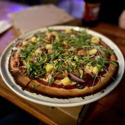 BBQ Jack Vegan Pizza on Gluten Free dough. Jackfruit, pinapple, jalapeño, red onion, vegan mozzarella, micro cilantro and BBQ sauce.