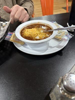 Medium size bowl of chili with diced onion and cheese. Yum!!