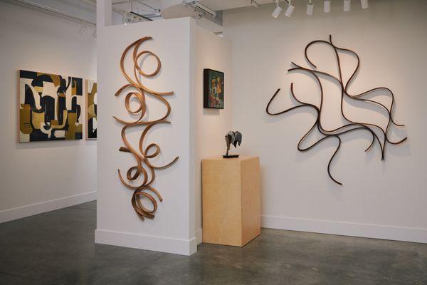 View of an exhibition at Kennedy Contemporary including wood sculptures by Heather Zusman and a collage painting by Elyse Katz