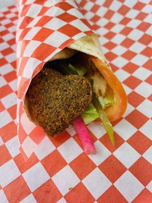 HEARTBEAT - wrap filled w/ heart shaped chickpea fritters, garnished w/ lettuce, pickles, pickled turnips, hummus, tomatoes - vegetarian