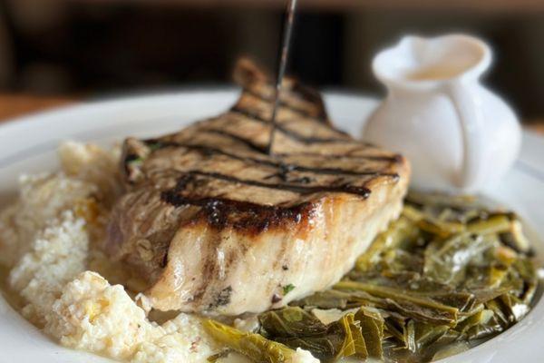 Smoked pork chop, collard greens, mustard cream sauce, and New Orleans grits.