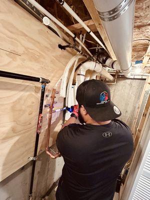 Expert heating installation underway! One of our skilled technicians meticulously setting up the piping for a new, high-efficiency boiler sy