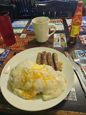 The Country Boy, hashbrowns topped with a biscuit topped with eggs, smothered in gravy and cheese with 4 sausages on the side.