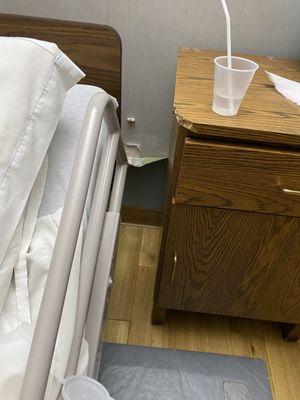 Wallpaper falling behind the bed.