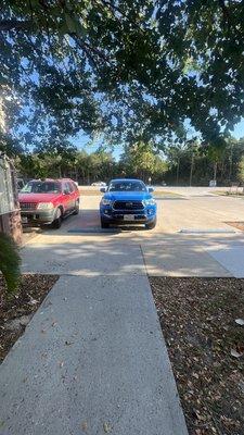 Owners vehicle parked between 2 handicap spots blocking  the pedestrian walkway to the martial arts next door