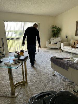 Osdani pre-spraying carpet before we begin the steam clean.