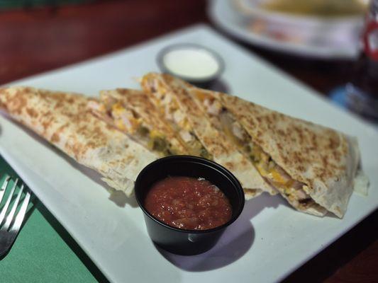 Chicken Quesadillas -
 Cheese, peppers, and onions. Served with salsa and sour cream.