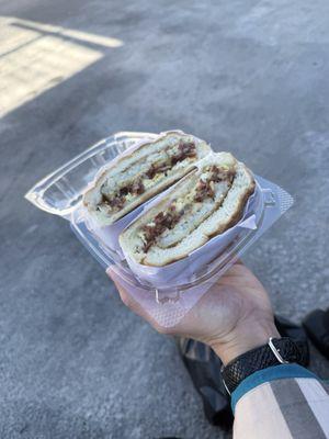 Bacon, egg, and cheese with hash brown on a bagel