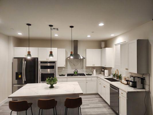 Estatuario quartz kitchen island and range countertops fabricated and installed by LA Countertops, featuring a full-height sleek backsplash.