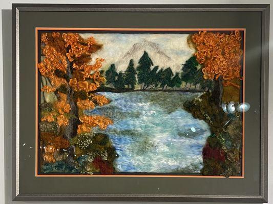 Wool painting in a silver frame with a triple mat to help bring out the color of the piece using museum grade glass.