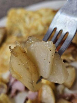 Close-up of a fork with some homefries.