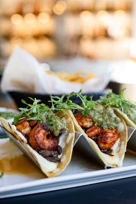The ultimate favorite - Mar & Tierra tacos. Bite into juicy carne asada, guajillo shrimp, guac, & micro-cilantro, all on a cheesy tortilla