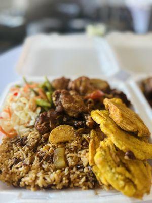 Rice and beans, fried chicken drizzled with sauce, fried green plantains, vegetable of the day (string beans/carrots/brocoli) and pikliz.