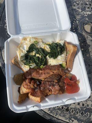 Avocado toast with eggs over easy with home fries, bacon and added spinach on top