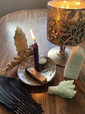 Smudge duck feather a fan, ocean jasper flame, purple ritual candle, palo santo, dragon head, and Caribbean calcite tower