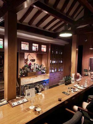 Inside Cobbler are a few counter seats w low chairs, and some tables behind.