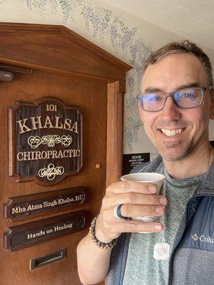 Enjoying a complimentary cup of tea after a refreshing adjustment by Dr. Mha Atma.