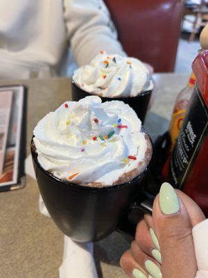 Hot chocolate with whipped cream and sprinkles.