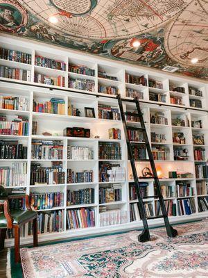 Custom shelving with sliding ladder in client's magical home library.