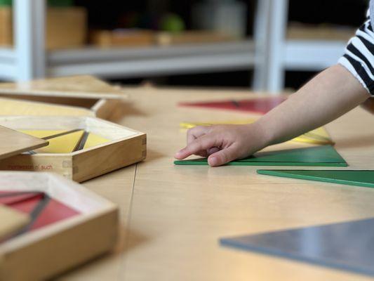 Montessori triangle box with colorful triangles, fostering creativity and geometry skills at Seedsowers Montessori Preschool.