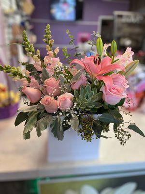 Elegant mix pink flowers and a Succulents plant in a white box