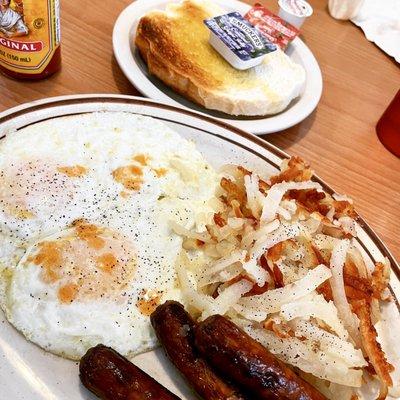 Eggs over easy with sausage and sourdough toast.