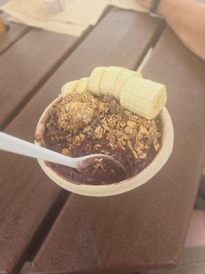 Monkey bowl, including banana, granola, honey, and cacao nibs with an acai base