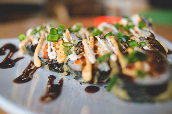 Carnival Roll - Tempura Shrimp deep fried roll with Hot Mess Mix, Cream Cheese & Avocado topped with Jalapeno, Spicy Mayo, Lime Crema, etc.