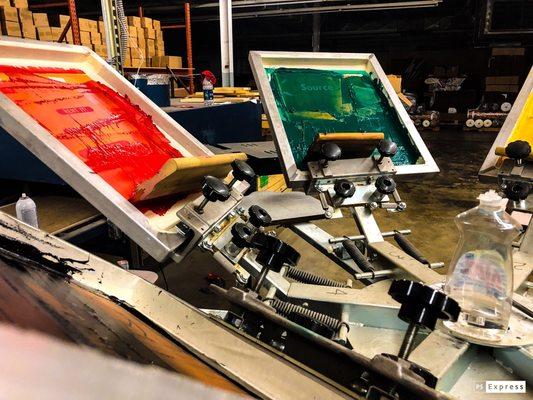 Screens on the press and printing late at night to meet deadline.