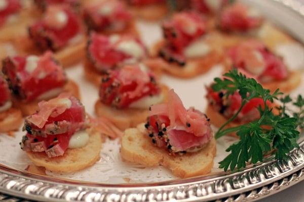 Seared Ahi Tuna with wasabi aioli on a wasabi crostini topped with pickled ginger
