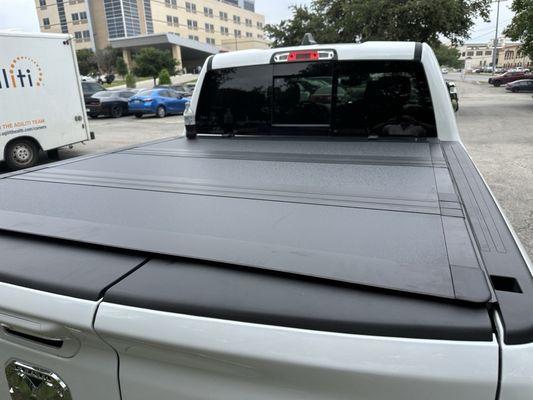 Installed Westin Tonneau cover for a 2025 Ram 1500 with cargo management system and split tailgate.