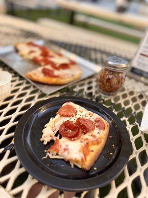 Slice of stacked pepperoni flat bread pizza.