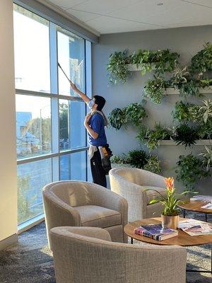 Window Technician cleaning the inside at an office