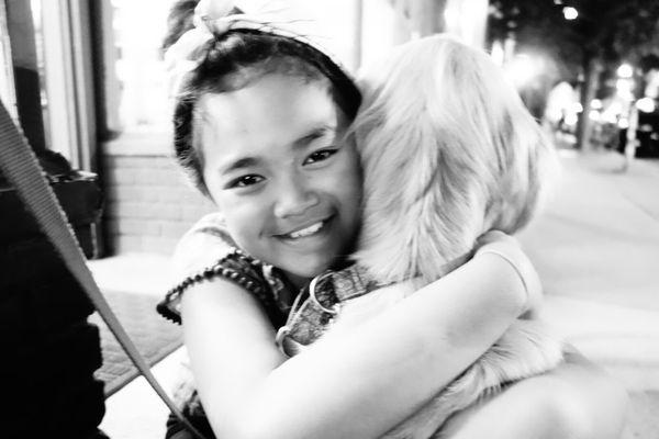 The owner's daughter greeting a puppy.
