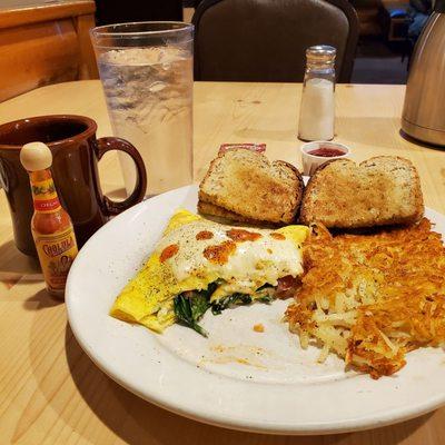 Veggie omelet with swiss, crispy hash browns, wheat toast, coffee and water. (my Cholula)