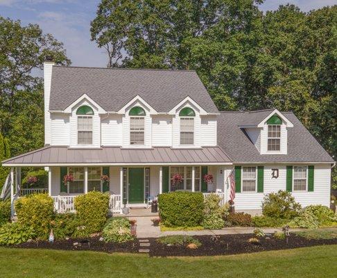 Roof replacement using metal on the porch and asphalt shingles on the main roof.