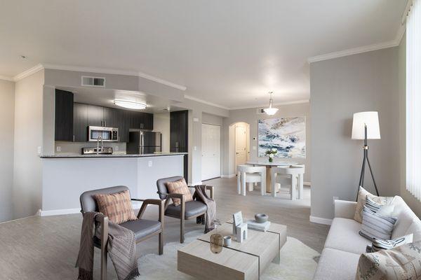 Open layout featuring a living, dining, and kitchen area with hardwood-style vinyl floors.