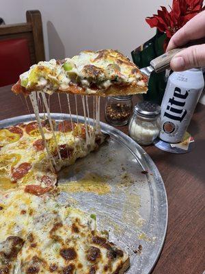 Half supreme and other half pepperoni and banana peppers. Look at that cheese pull!