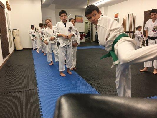 Kids performing slide behind back kick.