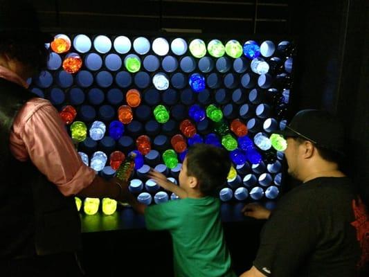 Children work an oversized light box in the Electricians Shop at The Rhelm.