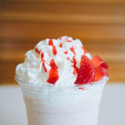 Strawberry Milkshake Topped With Raspberry Drizzle And Strawberries