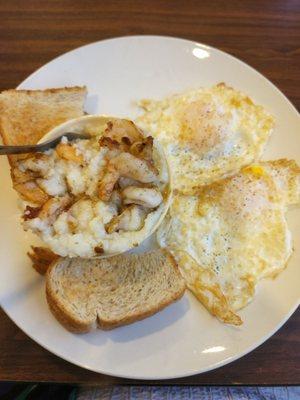 Shrimp and grits with 2 fried eggs and toast.