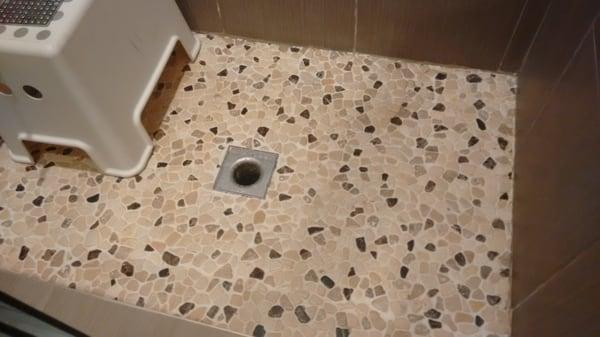 Improperly installed shower. LEAKS! Wrong drain (outdoor). No hot mop. Side tiles installed before floor.