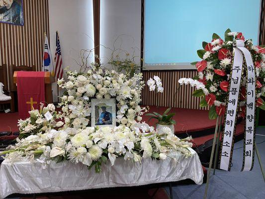 Memorial service spray and flowers around the picture.