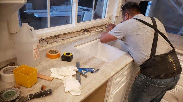 Installer photographing crack in sink